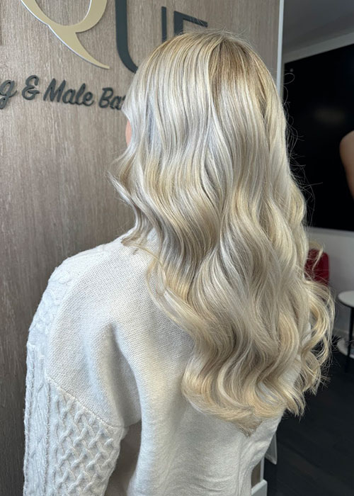 A hair model for Unique Hairdressing with bright blonde highlights.