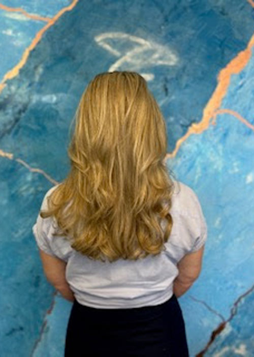 A woman's blow dried blonde hair.