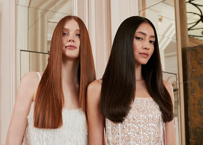 2 girls standing next to each other, one is ginger and the other is brunette.